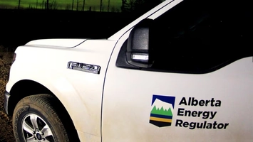 White Ford F-150 pickup truck with Alberta Energy Regulator logo on the door photographed at night outdoors